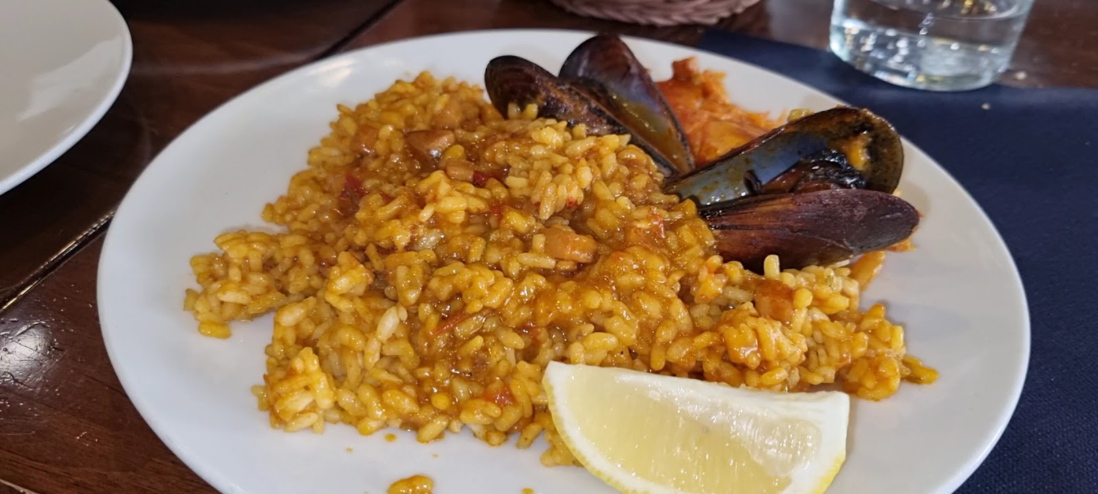 Rice dish with mussels and lemon wedge